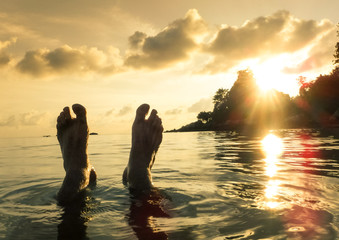Naked human barefeet at secret beach during sunset in Koh Lipe - Wanderlust travel concept with...
