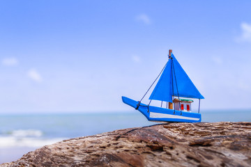 Miniature toy sailboat on the beach