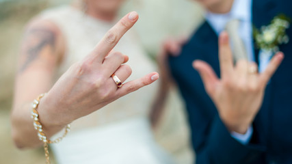 newlyweds show their hands with wedding rings, rock