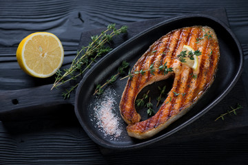 Grilled salmon steak with fresh thyme, lemon and pink salt