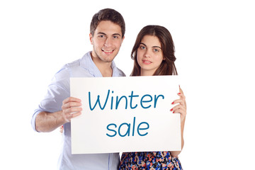 Couple holding cardboard with "winter sale".