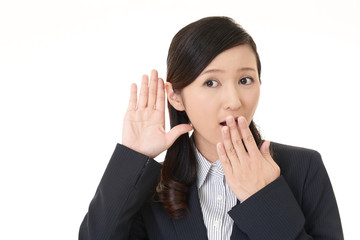 耳に手を当てる女性