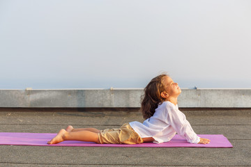 Baby doing yoga on the roof