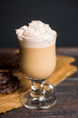Coffee and chocolate eclair on dark wooden background. Shallow depth of field.