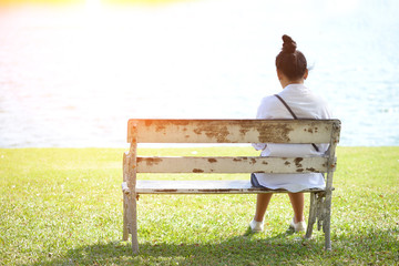 Woman sitting alone on a bench in the park