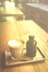 vintage art filter image of coffee latte art in cafe