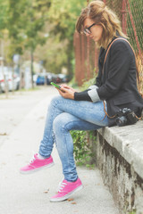 Girl using cellphone outdoors.