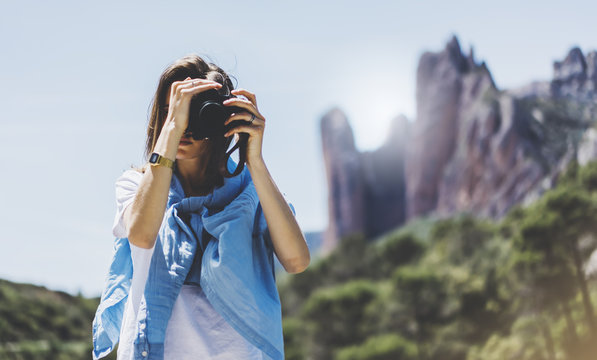 Tourist traveler photographer taking pictures of amazing landscape on photo camera on background valley view mockup sun flare, hipster girl enjoying peak of foggy mountain, nature holiday concept