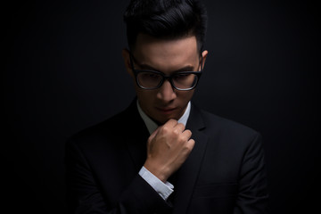 Businessman in black suit on isolated black background