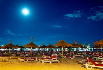Night beach with sun loungers in Alcudia, Mallorca.