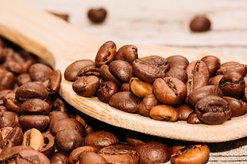 Wooden spoon with coffee beans on the table