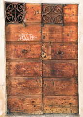 Vintage wooden entrance door with forged ironwork