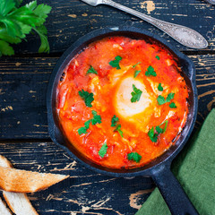 Eggs in tomato sauce with fried bread, top view, square