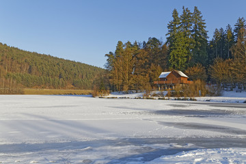 shack by a frozen lake