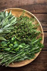 various fresh herbs, rosemary, thyme, mint and sage on wooden background