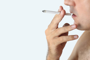 Close up portrait of young man smoking cigarette