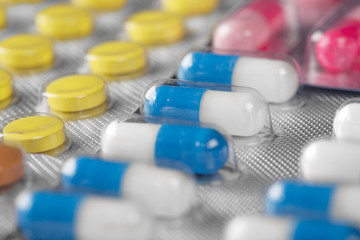 medical pills in different colors in plastic containers