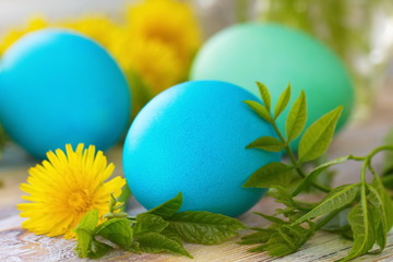 Easter eggs and flowers on wooden background