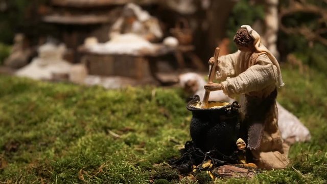 animated statuette of the crib of a woman who mixes the food in a cauldron