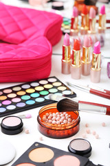 Different makeup cosmetics on white table