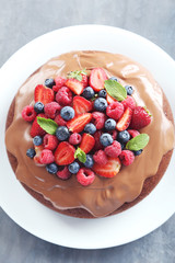 Homemade chocolate cake with berries on grey wooden table