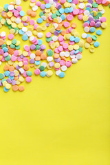 Colorful sprinkles on a yellow background