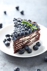 Tasty piece of cake with blueberries on wooden table