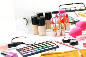 Different makeup cosmetics on white table