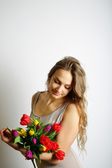 Cute girl holding a bouquet of colored tulips