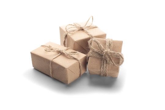 Boxes with gift wrapped in kraft paper on isolated background