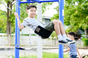 Asian boy play with swinging.