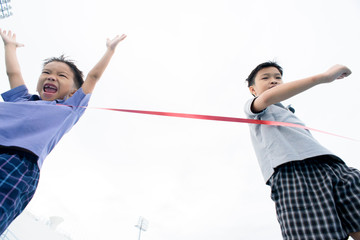 Young Asian boy running on blue track in the stadium