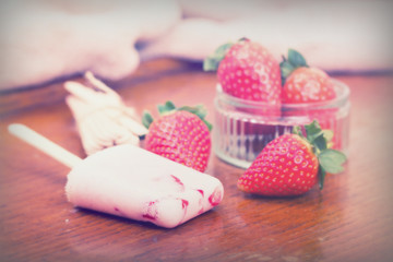 Fototapeta na wymiar Homemade strawberry ice lolly on rustic background