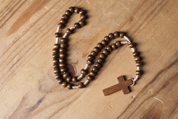 Christian rosary on wooden table
