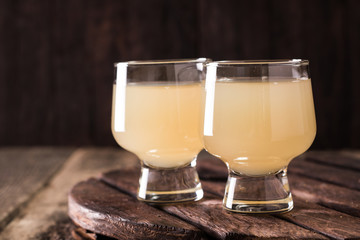 Pineapple slices and juice in glassware on wooden table