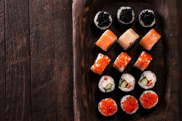 Various kinds of sushi served on a platter with soy sauce, wasabi and pickled ginger.