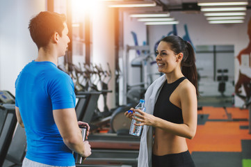 Fit woman discussing about gym with her personal trainer