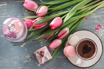 romantic breakfast Cappuccino ,strawberry macaroons, pink tulips, gift box on blue table.Valentine's day concept