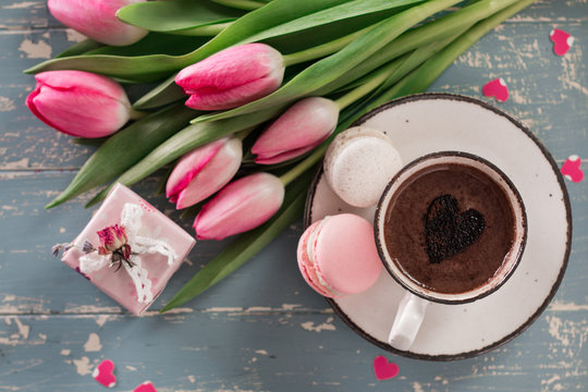 romantic breakfast Cappuccino ,strawberry macaroons, pink tulips, gift box on blue table.Valentine's day concept
