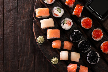 Various kinds of sushi served on a platter with soy sauce, wasabi and pickled ginger.