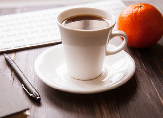 Workplace background: notebooks, a keyboard and a cup of coffee