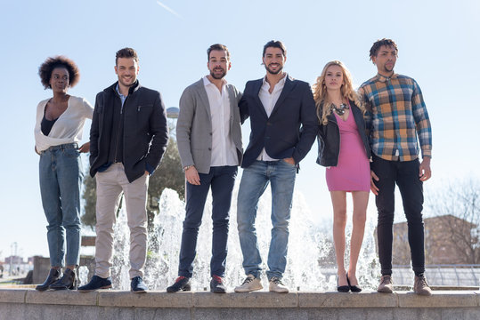 Portrait of friends standing on the fountain
