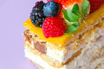 Detail on fruit cake made with cream, custard and assorted fruits as kiwi, strawberry, raspberry, blackberry and blueberry