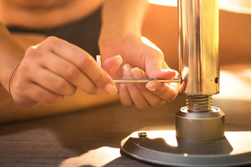 Close up of young woman hands adjusting a pole using hexagonal key key tool. Selective focus.