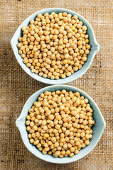 soybeans in ceramic bowl on sackcloth background..