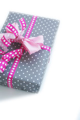Pacco regalo con fiocco rosa su sfondo bianco
