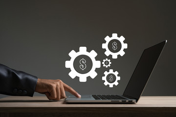 Businessman touching on laptop with gear wheel setting.