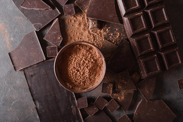 Chocolate  chunks and cocoa powder. Chocolate bar pieces.  A large bar of chocolate on gray...