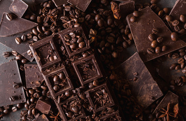 Chocolate, coffee beans. and cocoa powder. Chocolate bar pieces. dark chocolate background. A large bar of chocolate on gray abstract background. Background with chocolate. Slices of chocolate