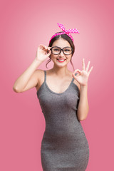 Fashion portrait of asian girl with sunglasses standing on pink